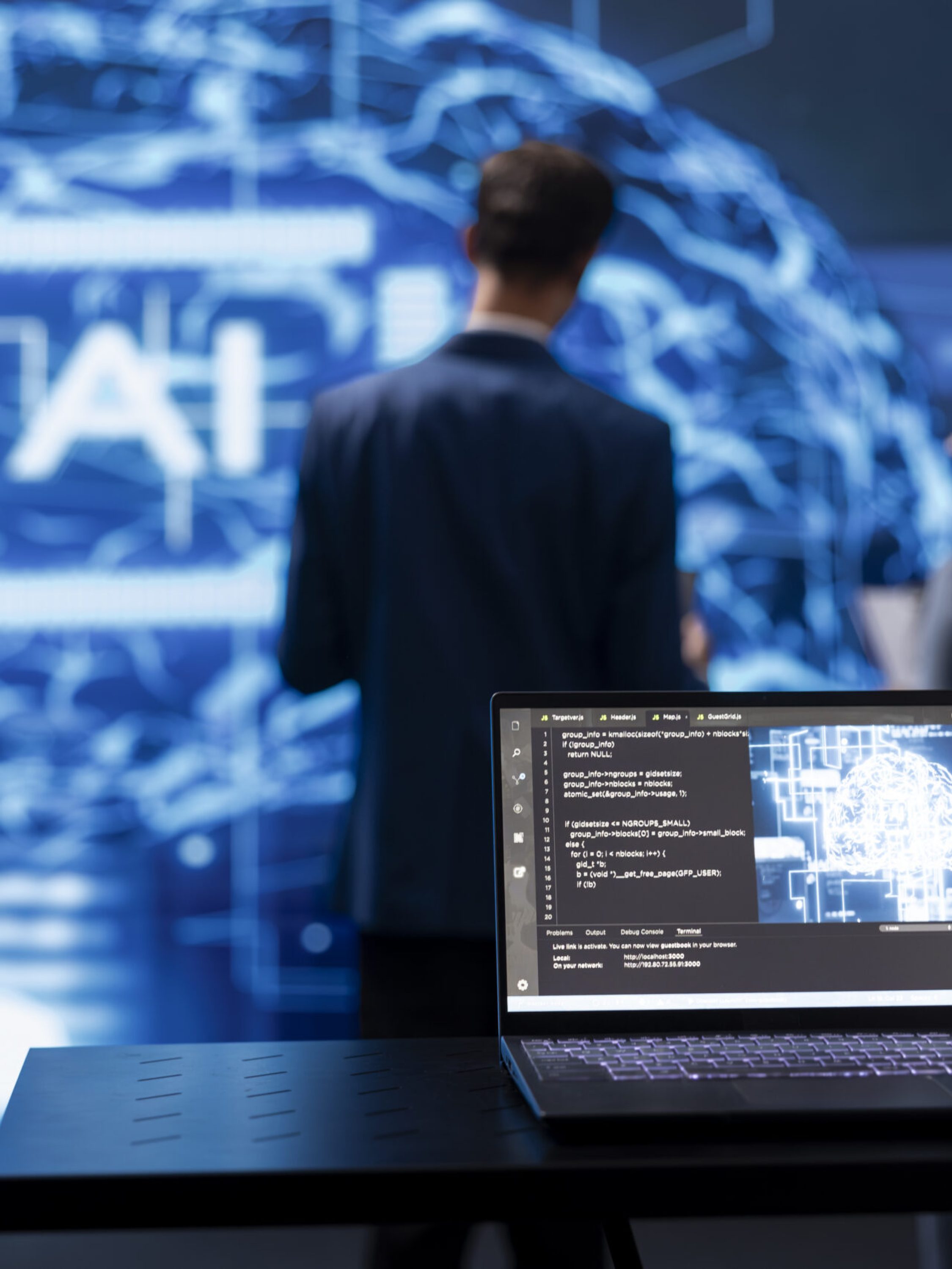 Focus on laptop running AI cognitive computing tech used by IT staff members in blurry background. Close up of notebook used by teamworking engineers to do data mining with self learning algorithms